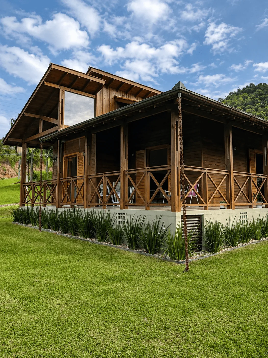Casa de madeira Castello com varanda ampla em volta e jardim